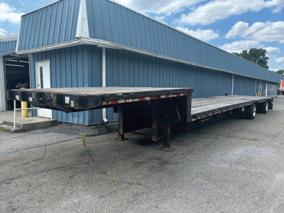 Great Dane Freedom SE drop deck trailer in serviceable condition showing long flatbed with ramps folded at front and dual rear axles.