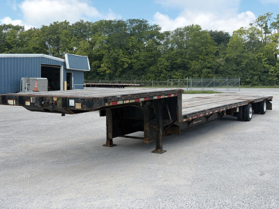 2018 Great Dane Freedom SE drop deck trailer showing long flatbed with multiple axles and undercarriage, storage box, and surrounding lot.
