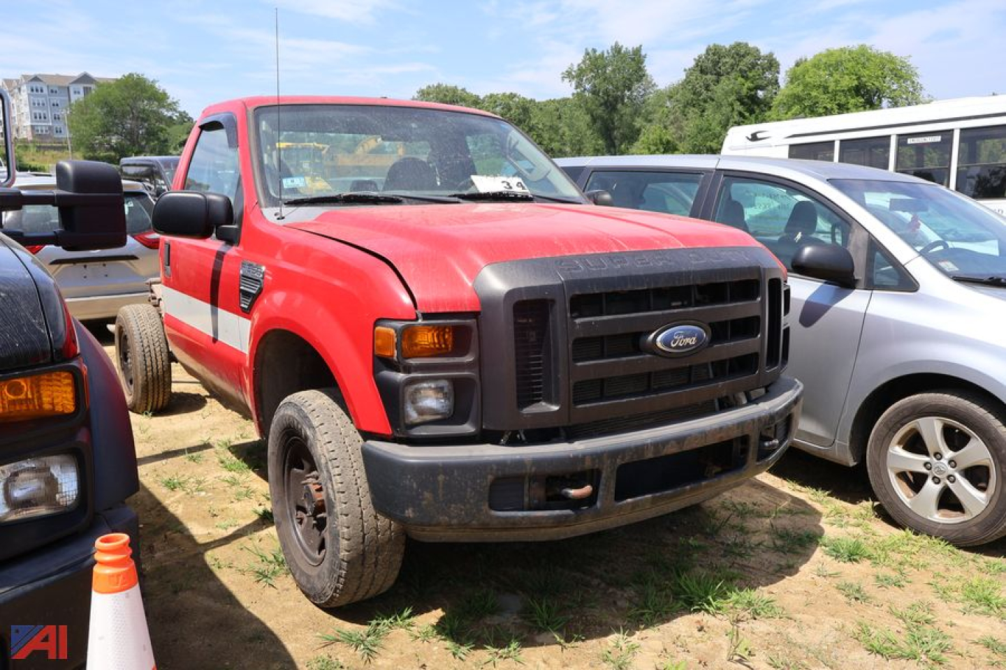 Front view of a red 2008 Ford F-350 Super Duty pickup truck in a used vehicle lot. prominent black grille with Ford emblem, rectangular headlights, black front bumper, side mirrors, and visible wheel wells.