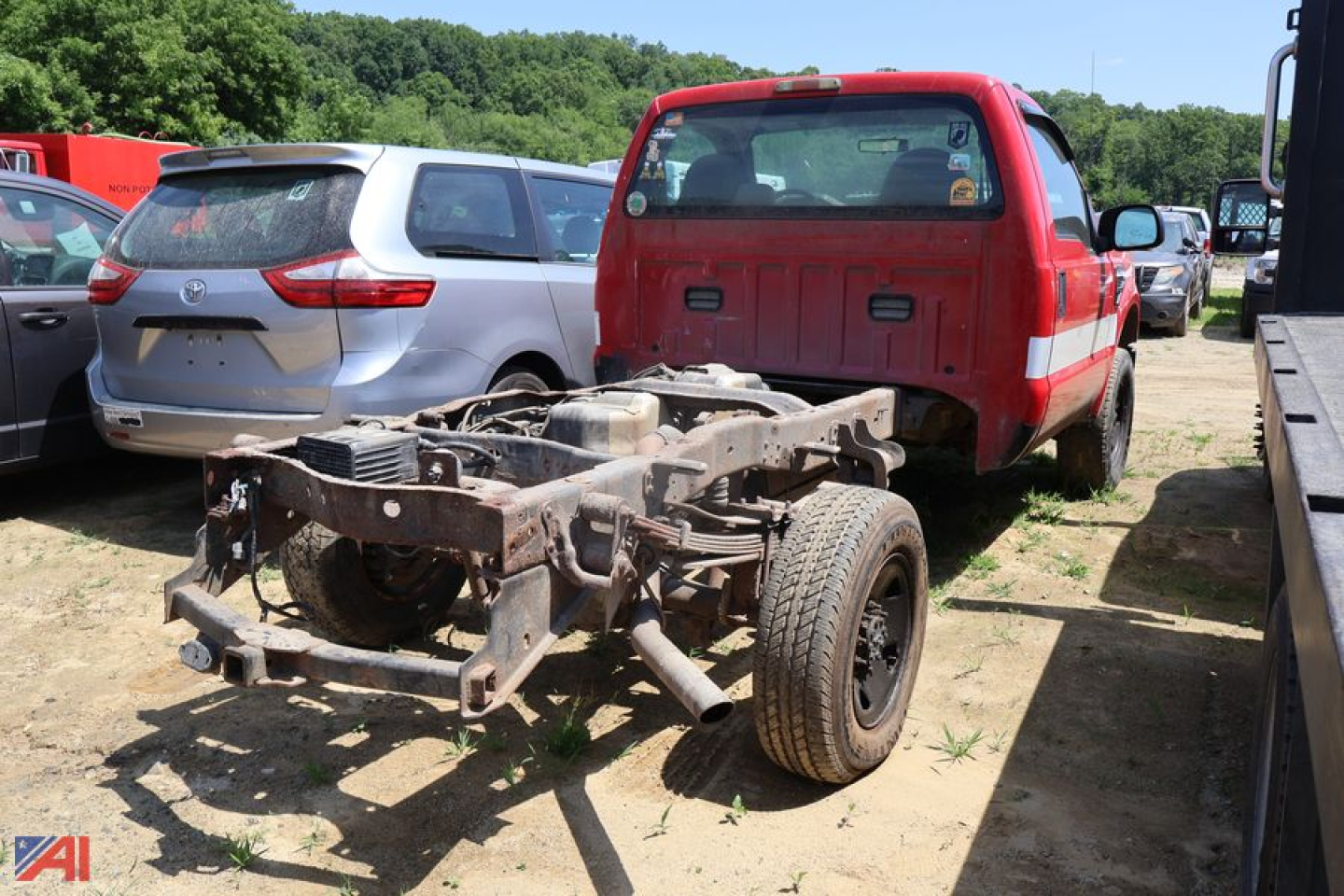 Ford F-350 Super Duty pickup truck chassis and cab with exposed frame and rear wheels in a yard.