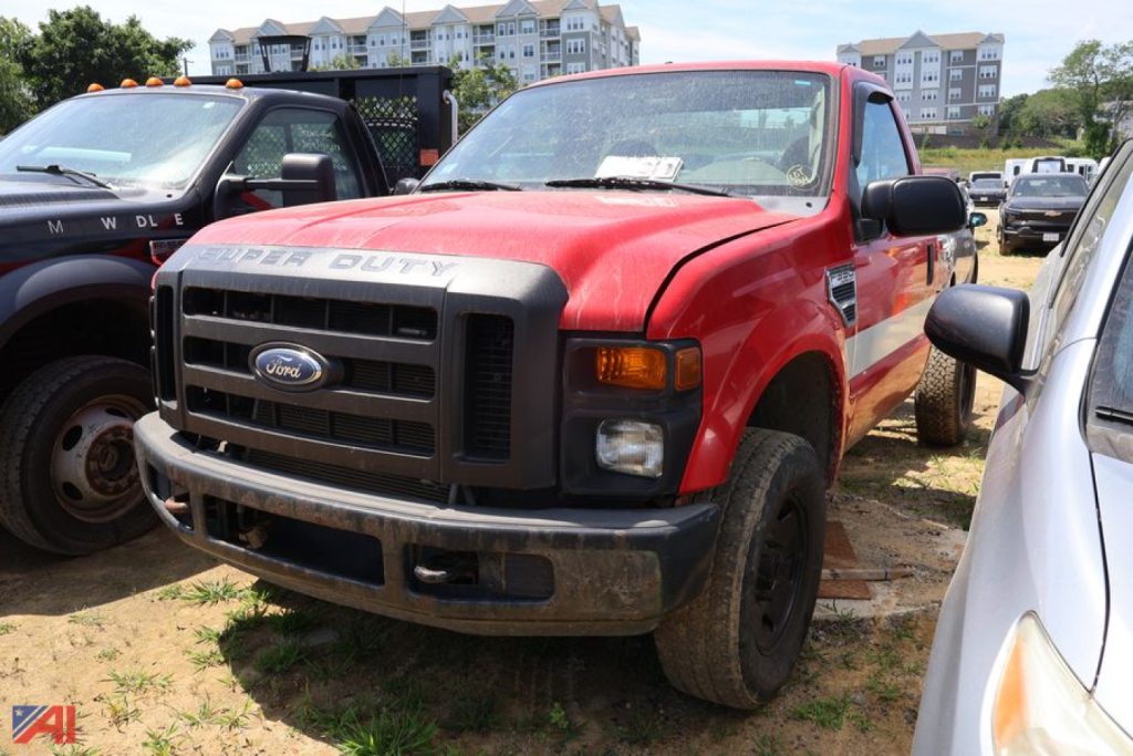 Ford F-350 Super Duty pickup truck in red with front grille and bumper, 4x4 badge, black mirrors, and worn tires.