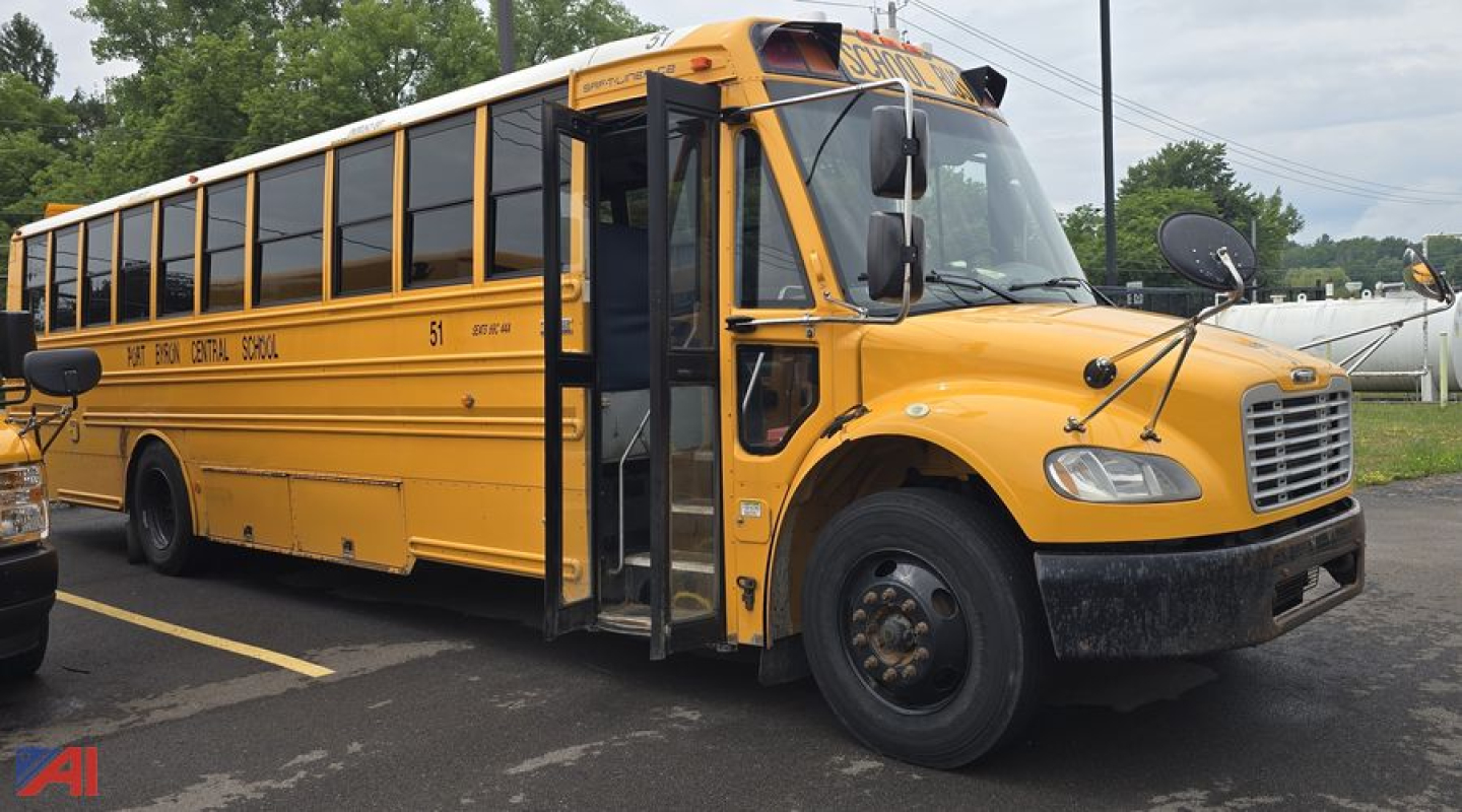 School bus side view showing Freightliner Thomas B2 Saf-T-Liner C2, yellow body, black tires, partial text on side windows and above windshield. Text includes bus markings and model lines.