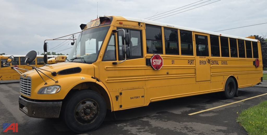 Yellow Freightliner Thomas Saf-T-Liner C2 school bus with stop sign and large front grille; visible text includes STOP sign, '51' door, 'PORT', 'B21', and other route markings along side.