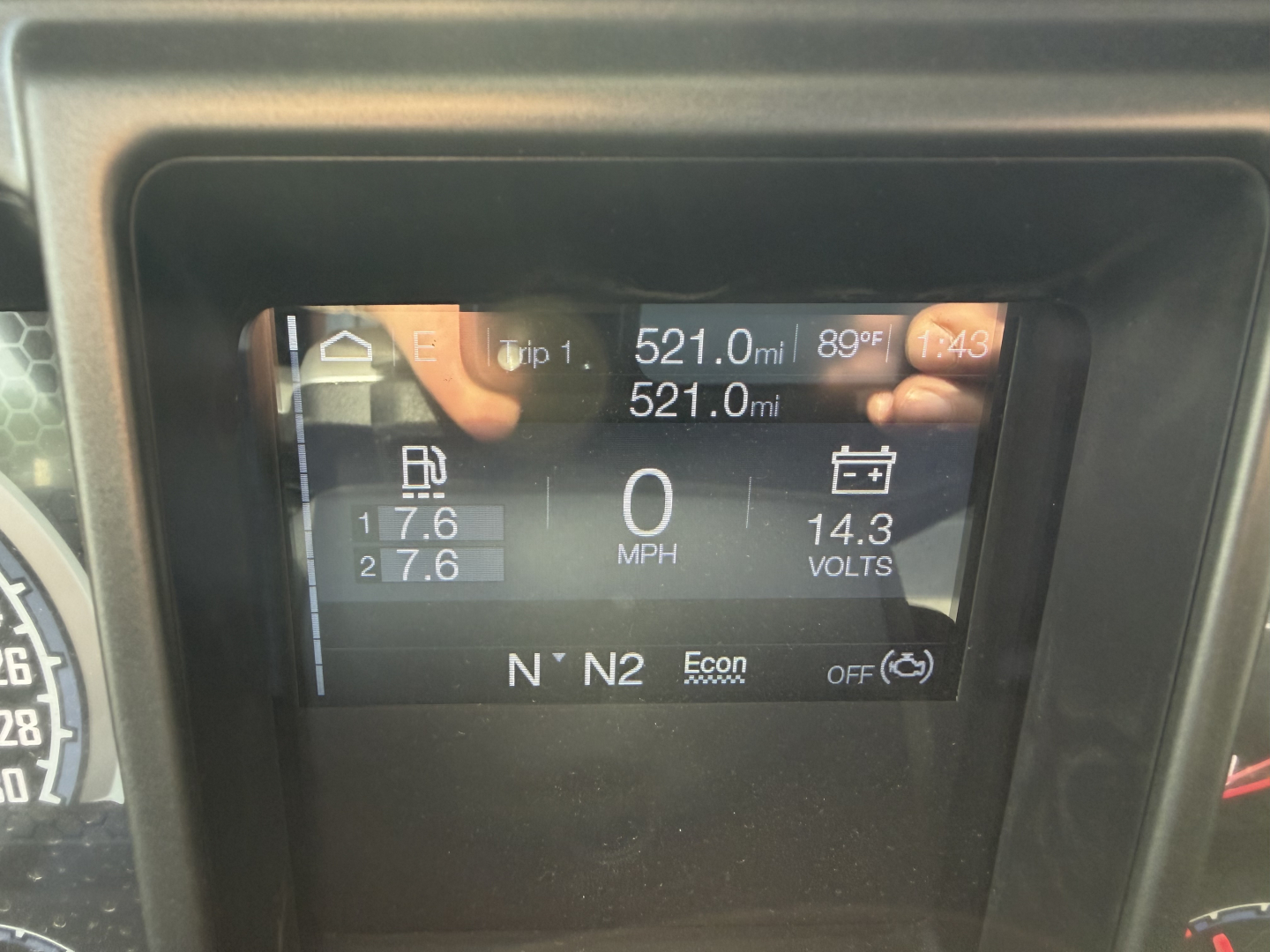 Dashboard display showing trip data: 521.0 mi; 89°F; 0 MPH; 14.3 volts; two fuel gauges; N N2 Econ OFF; digital icons on a Mack truck dash.