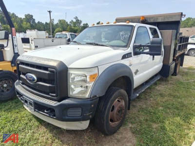 Ford F-450 Super Duty dump truck visible from front-right with dump bed raised, white cab, gray grille, large side mirrors.