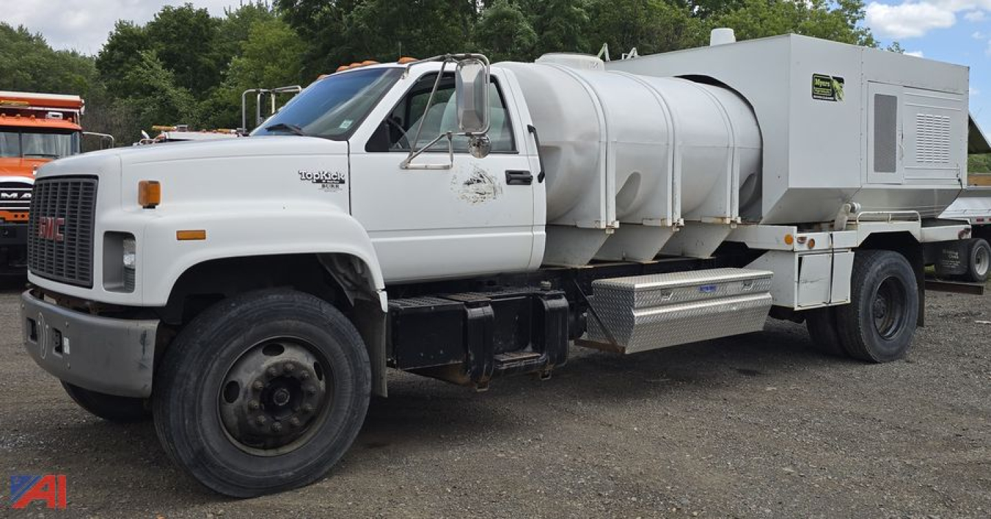 GMC TopKick C7500 tank utility truck with large stainless steel tank and utility box on the bed, front left view