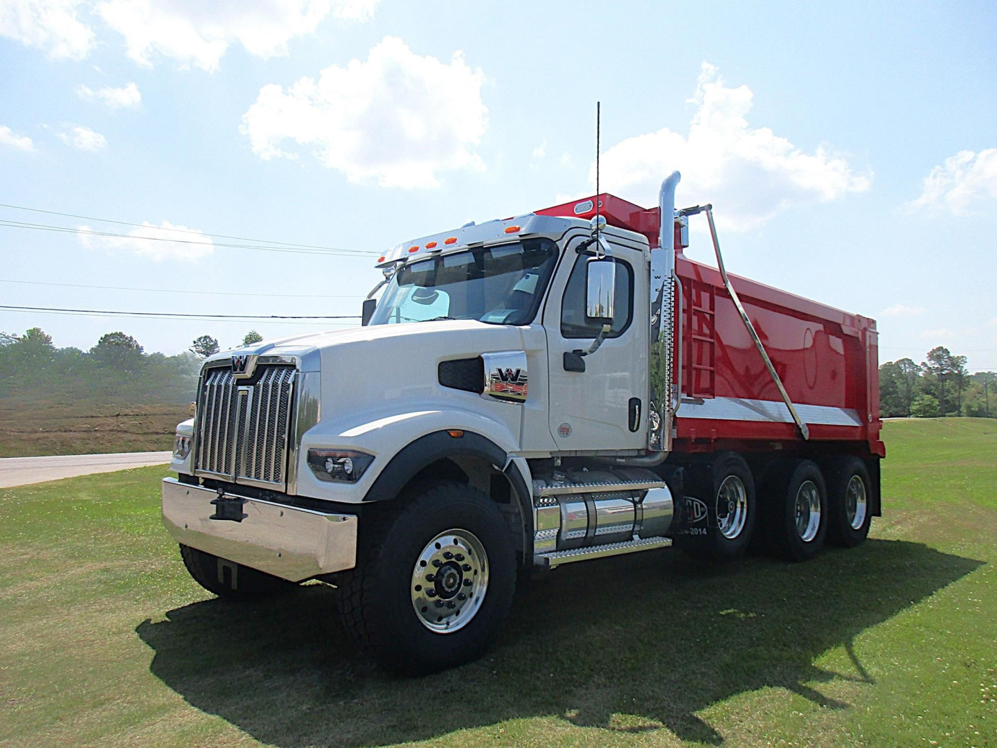 Western Star 49X dump truck showing cab and red dump body with chrome fuel tanks and dual rear axles.