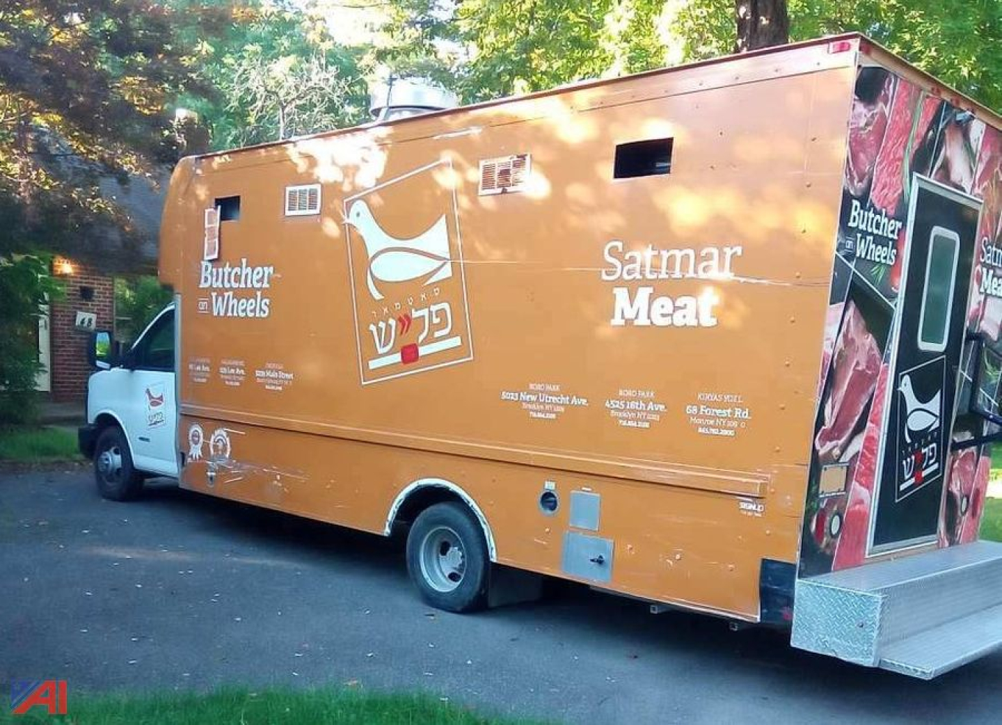 Food truck body with orange exterior, Chevrolet Express G4500 style cargo area. Side graphics show 'Satmar Meat', 'Butcher Wheels' and Hebrew text. Small windows and service/vent openings along side.