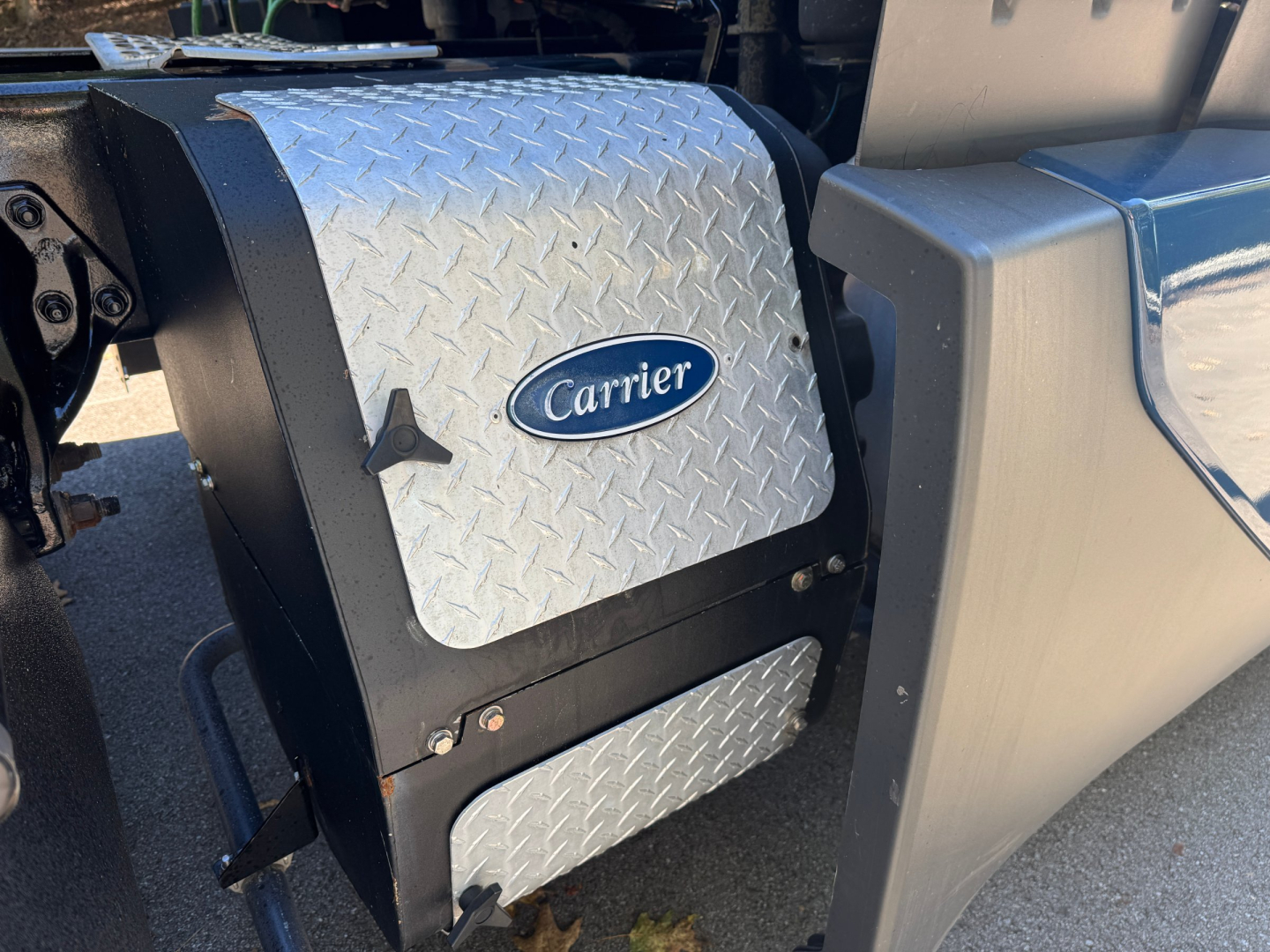 Carrier auxiliary power unit cover and Diamond Plate access panel on a 2024 Kenworth T680 engine area