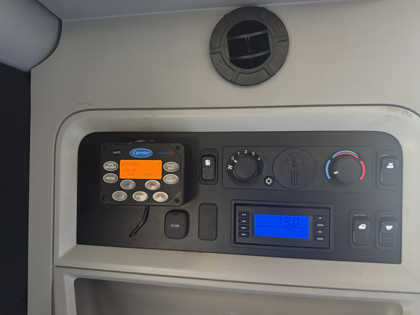 Kenworth T680 dash cluster with stereo display and control panel showing digital readouts.