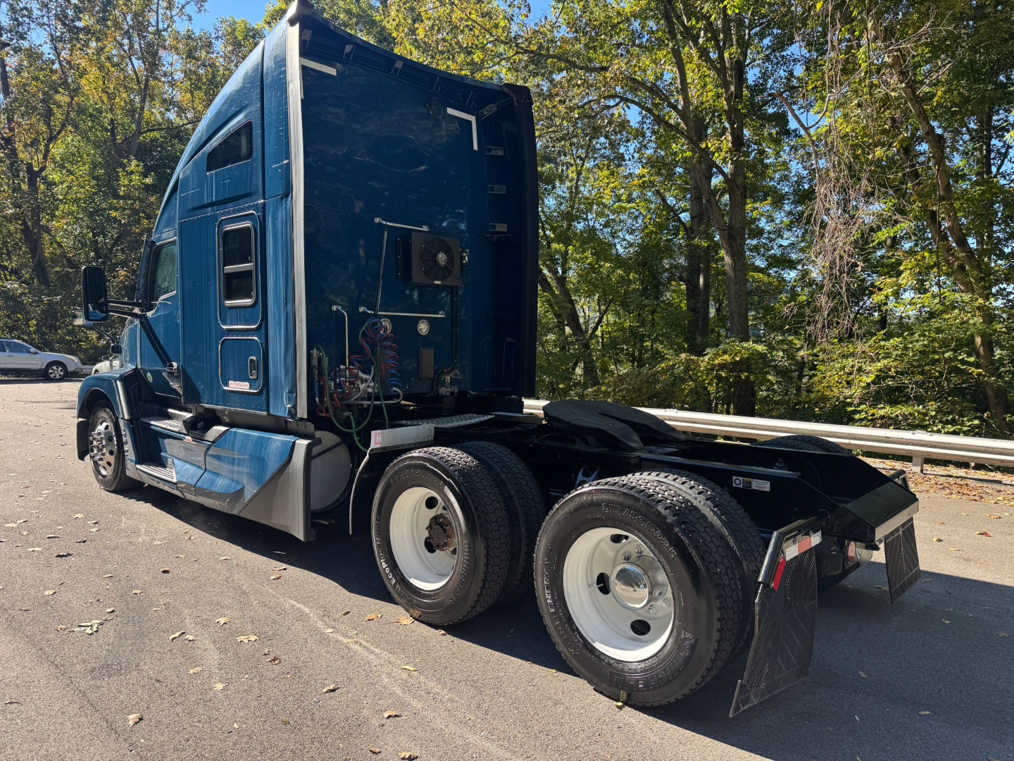 Kenworth T680 tractor cab rear and side view showing sleeper, dual rear axles, and fifth-wheel area; blue exterior with visible wiring and engine bay access.