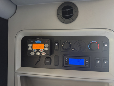 Kenworth T680 dash cluster with stereo display and control panel showing digital readouts.