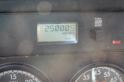 Dashboard view showing hour meter with 25000.5 hours and an engine indicator, along with partial gauges and brake light. 