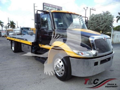 2019 International Durastar 4300 rollback truck with yellow and black livery, cab front view, chrome bumper, and flatbed carrier.