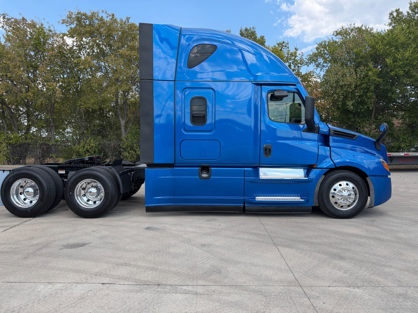 Freightliner PT126064ST sleeper cab truck side view showing blue exterior, large aerodynamic cabin, dual rear axles, chrome wheels, and side mirrors.