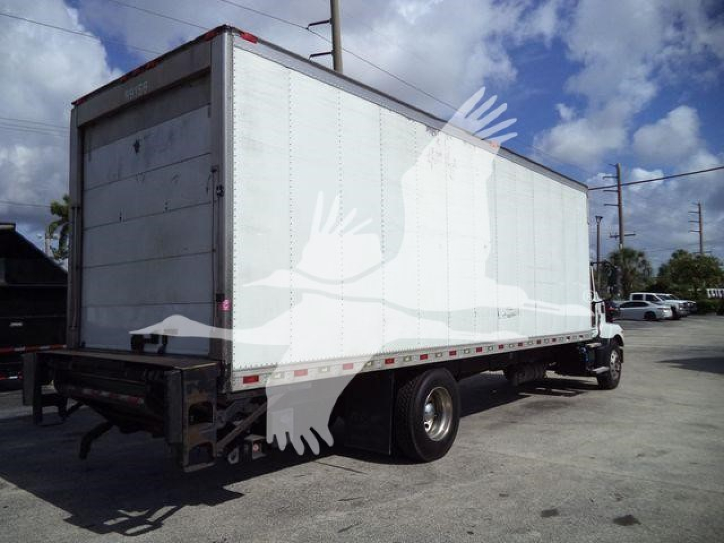 Truck rear/side view of a 2023 Mack MD6 refrigerated box truck in service showing cargo box with white exterior and rear doors.