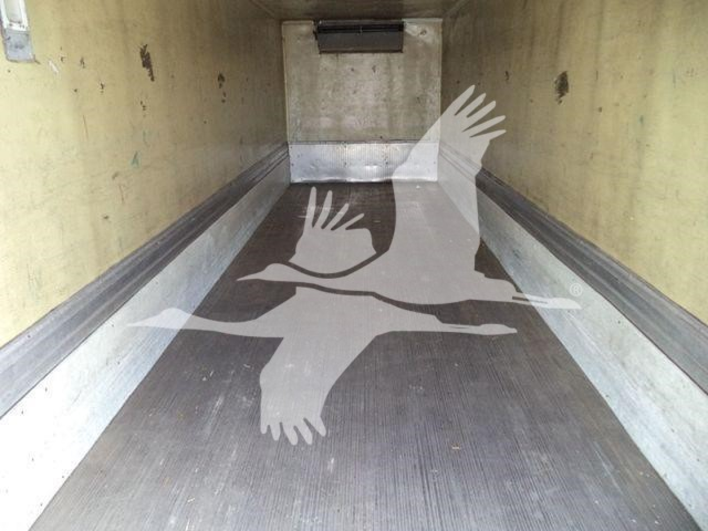 Interior of a refrigerated Mack MD6 cargo area showing clean aluminum sidewalls and ribbed flooring with no visible clutter.
