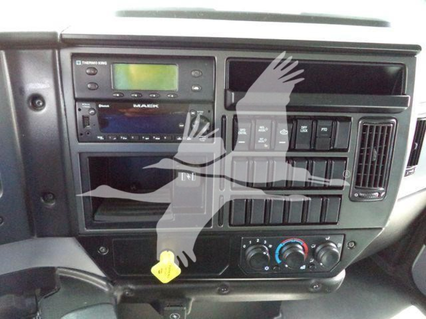 Mack MD6 dashboard area showing radio, climate controls, and multiple switches.