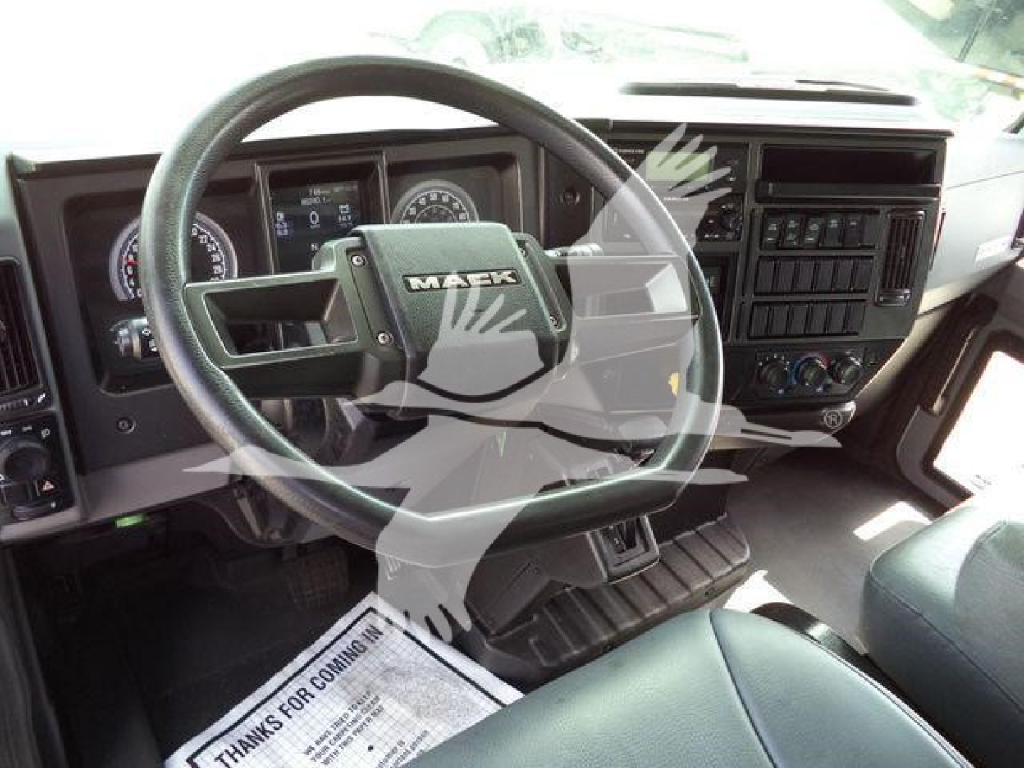 Mack MD6 truck interior view showing steering wheel and dashboard.