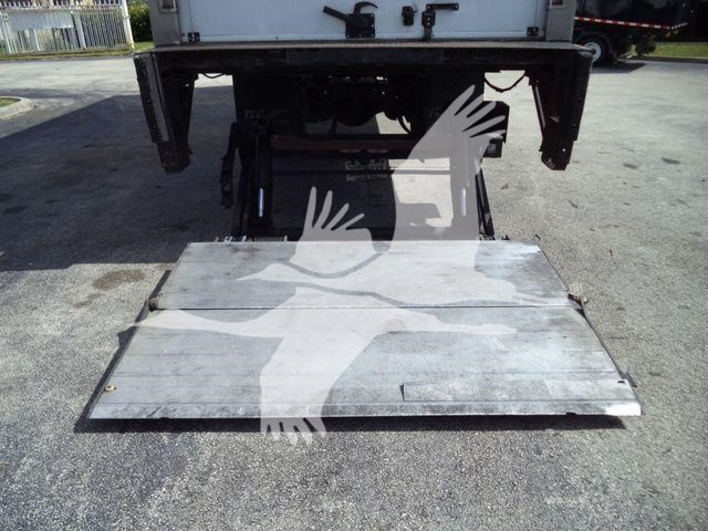 Mack MD6 truck rear with aluminum lift plate/platform for refrigerated body, underside view showing tail area and towing/receiver components.
