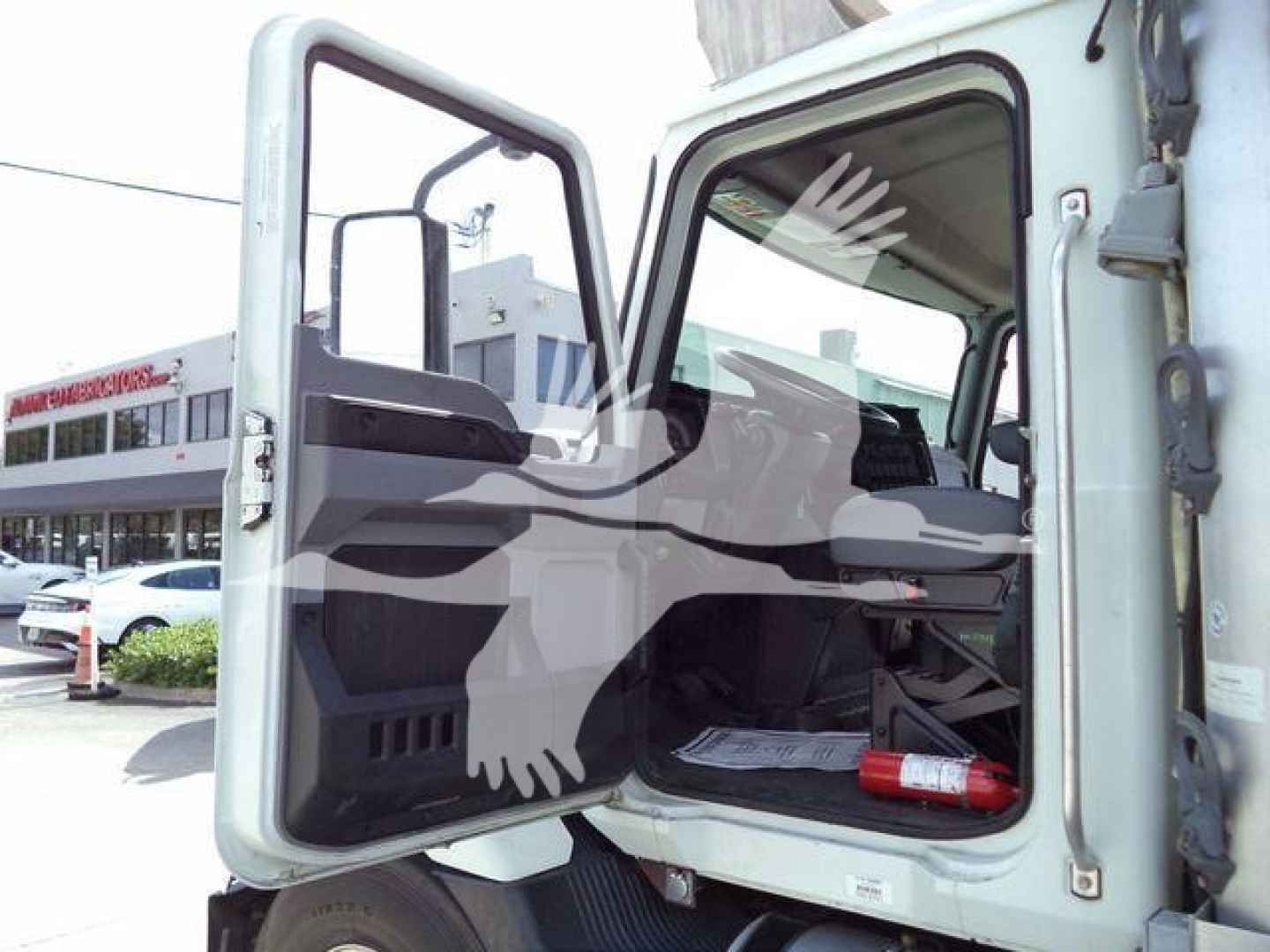 Mack MD6 truck cabin with front door open showing interior dash and steering wheel.
