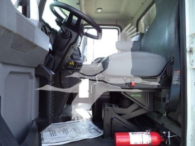 Cab interior of a 2023 Mack MD6 refrigerated truck showing driver seat, steering wheel, and dashboard from side view.