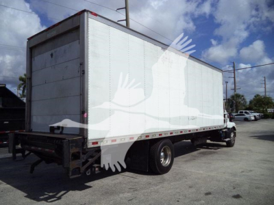 Truck rear/side view of a 2023 Mack MD6 refrigerated box truck in service showing cargo box with white exterior and rear doors.