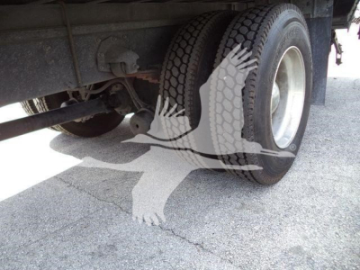 Rear view of a Mack MD6 truck showing dual rear tires and suspension components.