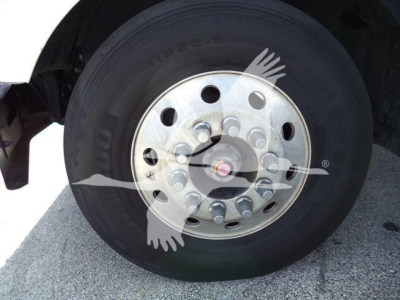 Rear wheel of a Mack MD6 truck showing a steel hub with multiple lug nuts and a black tire.