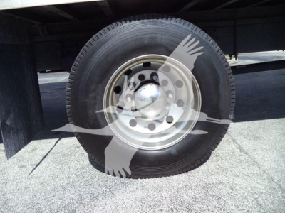 Wheel and tire on a Mack MD6 truck showing steel hub and rim with a protective overlay graphic.