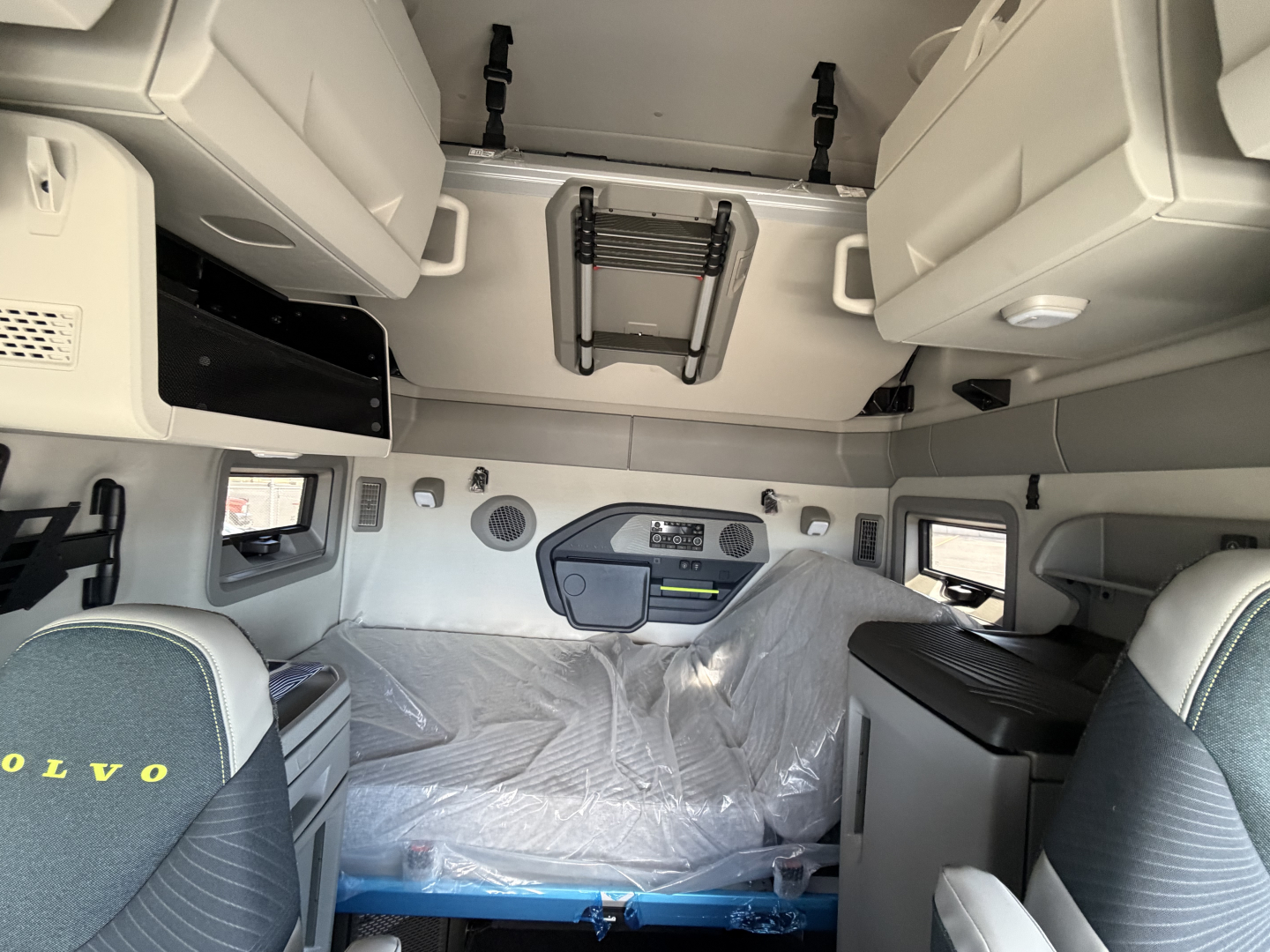 Volvo VNL64T860 cab interior showing sleeper area with overhead storage compartments and control panel in the dash area.