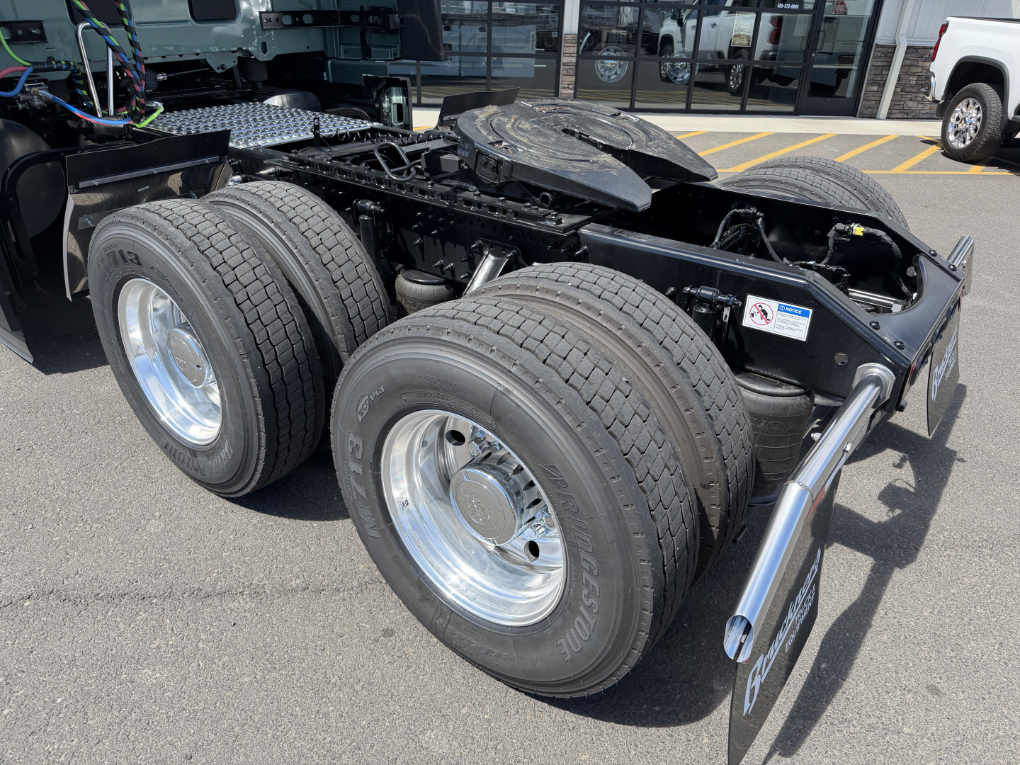 Volvo VNL chassis showing dual rear axles and wheel rims, visible fuel/tank area and truck components.