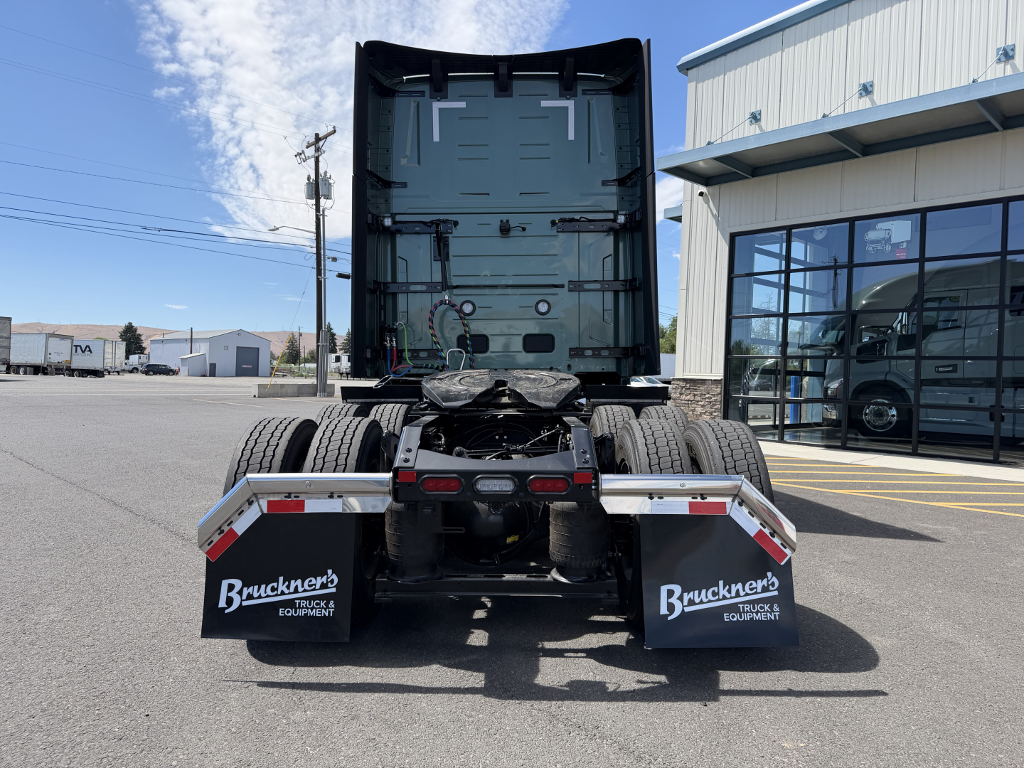Volvo VNL64T860 tractor truck rear view showing dual rear wheels and mud flaps with Bruckners Truck Equipment branding.