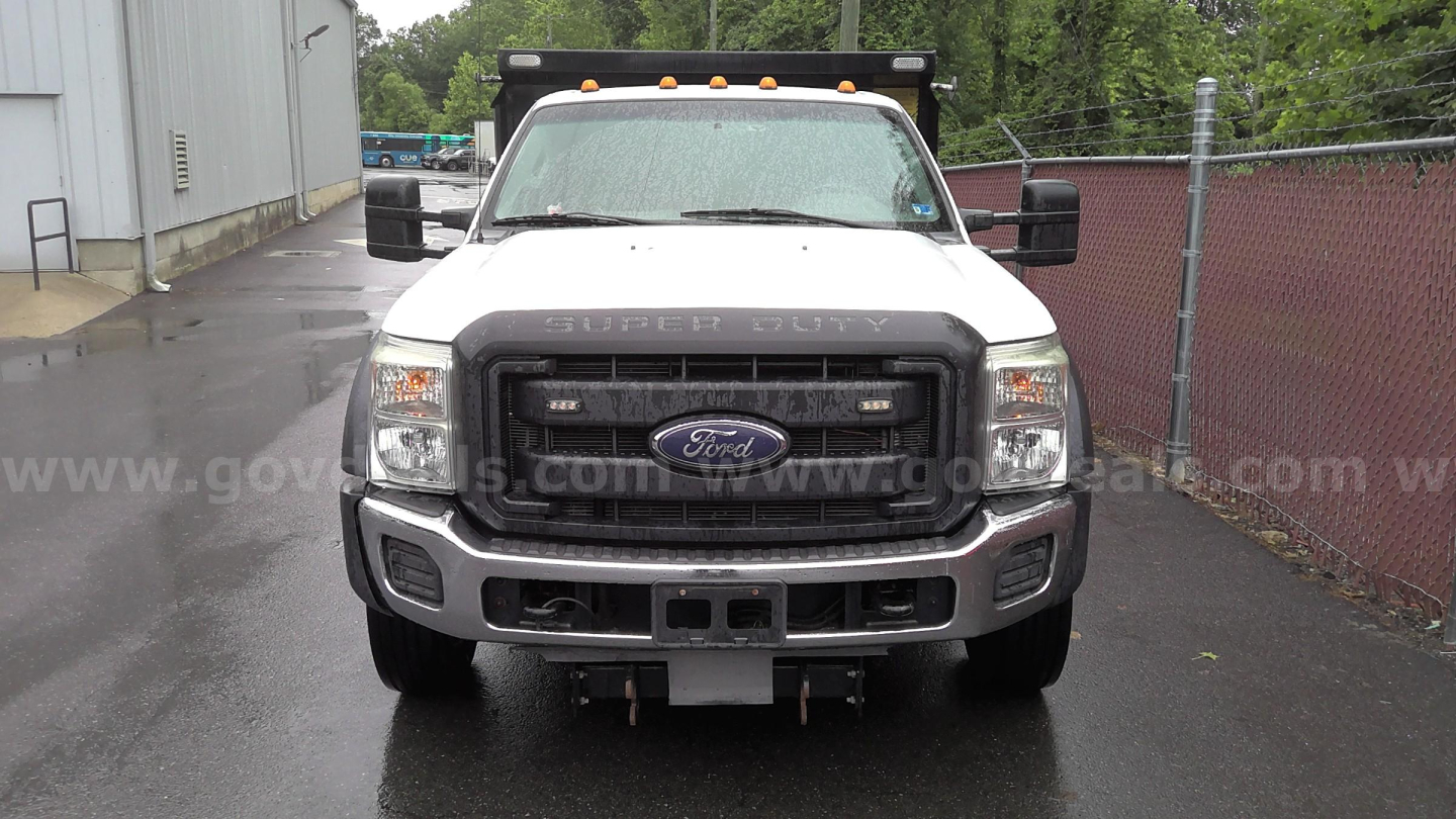 Ford F-450 dump truck front view showing Ford emblem grille and bumper, with yellow clearance lights on cab roof.