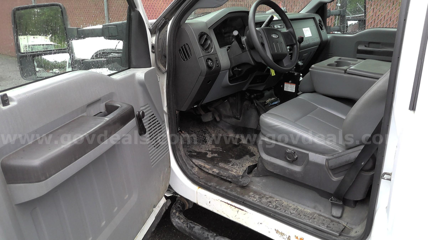 Ford F-450 truck interior showing front seats and dashboard from open driver door, with steering wheel and floor area visible.