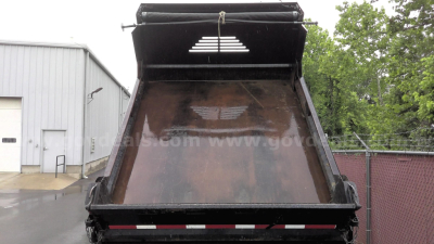 Dump truck bed of a 2013 Ford F-450 showing the cargo bay painted brown with a raised tailgate and black frame.