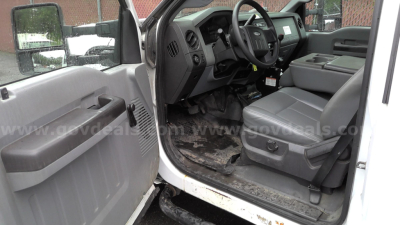 Ford F-450 truck interior showing front seats and dashboard from open driver door, with steering wheel and floor area visible.