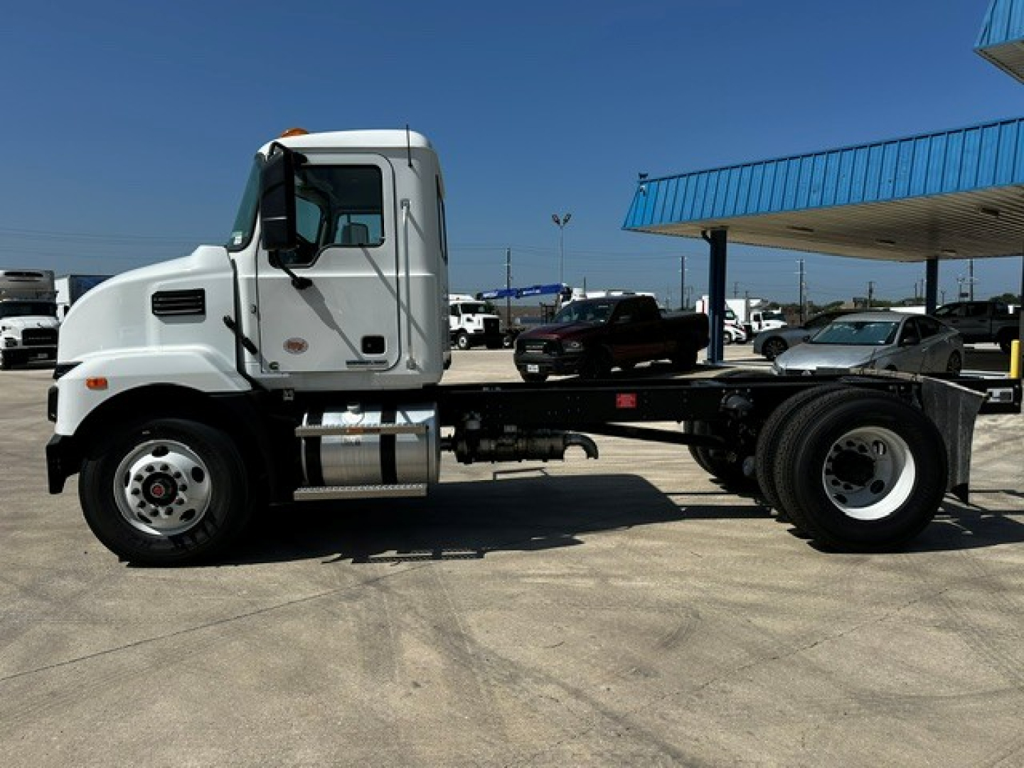 Mack MD6 cab and chassis truck in a parking lot, side view.
