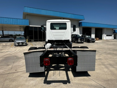 Truck chassis rear view showing cab and chassis with dual rear wheels and metal step/fenders.