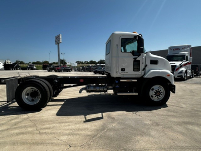 Mack MD6 cab and chassis truck side view showing empty chassis and white cab, with black chassis rails and front wheels visible.
