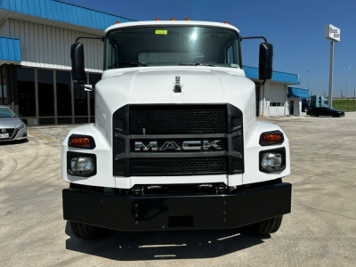 Mack MD6 cab and chassis front view showing large black grille with MACK lettering, white cab, black bumper, oval headlights, and side mirrors.