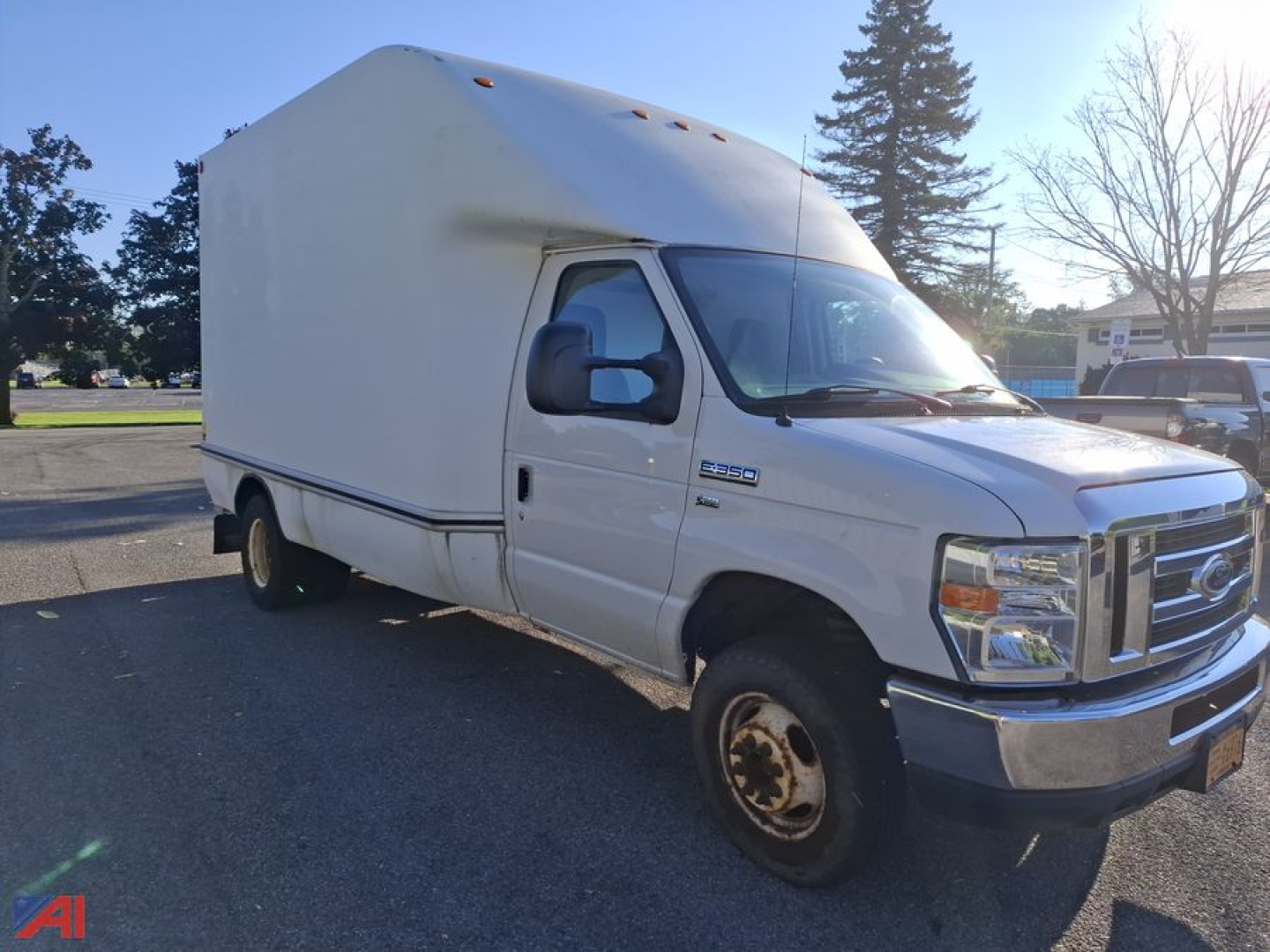 Ford E-350 box truck with high box and cargo area, front cab, single rear wheel, side mirror, and headlights visible.