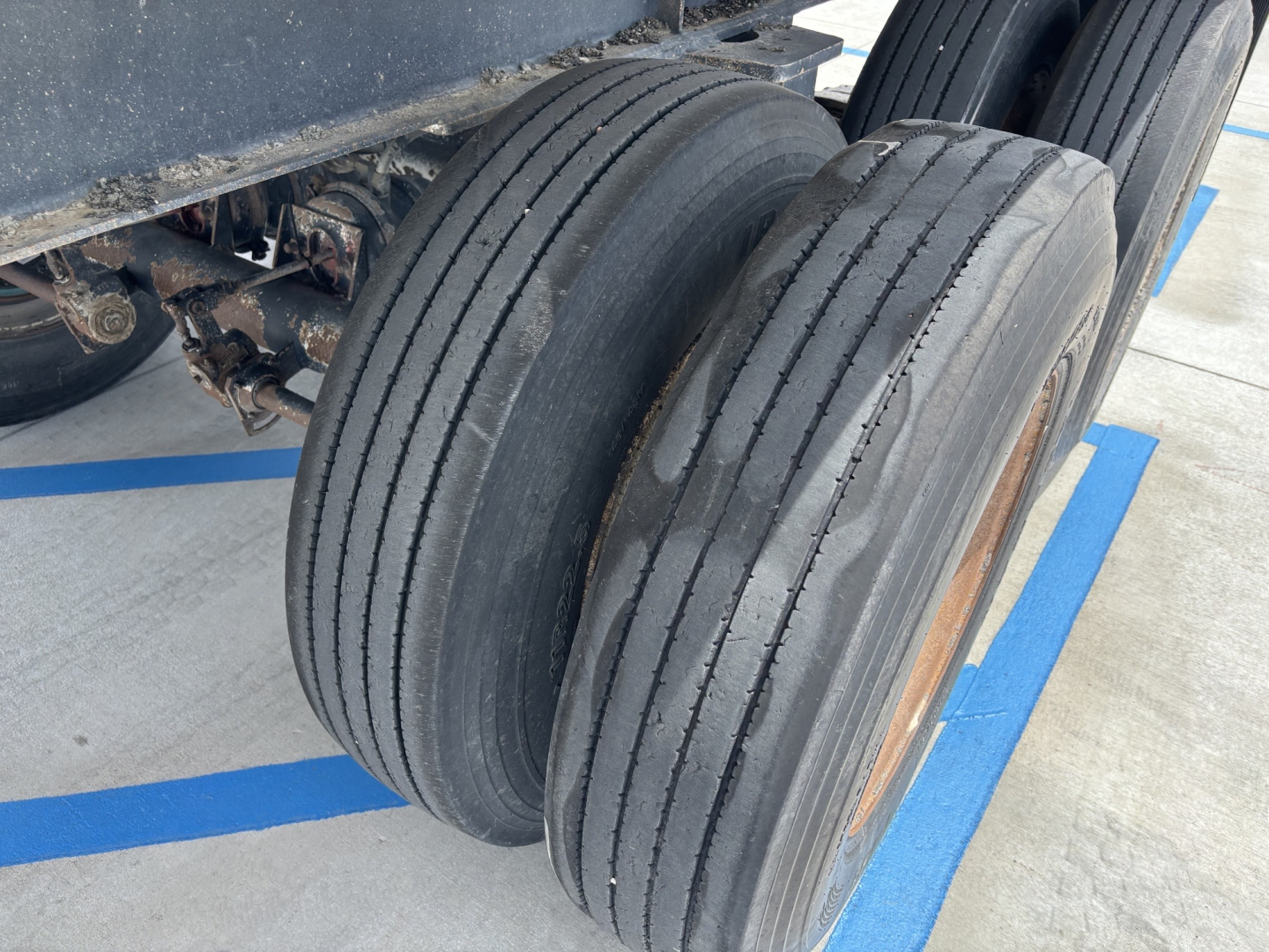 Travis S-96 dump trailer wheel assembly showing dual tires and undercarriage components.