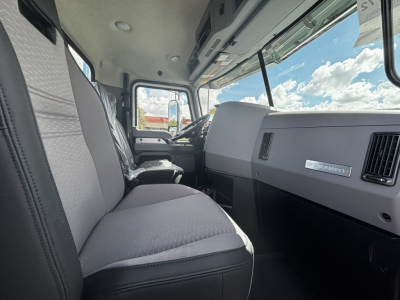 Cab interior of a new 2027 Mack GR64FT daycab showing front seats, dashboard, steering wheel, and large windows.
