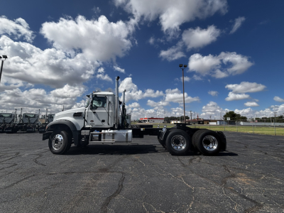 2027 Mack GR64FT conventional daycab truck side view showing chrome fuel tanks, dual rear axles, and long wheelbase.