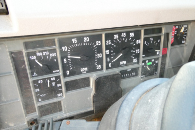 Instrument cluster showing gauges: water temp, RPM, speedometer, and warning lights in a 1998 International 4900 dashboard.