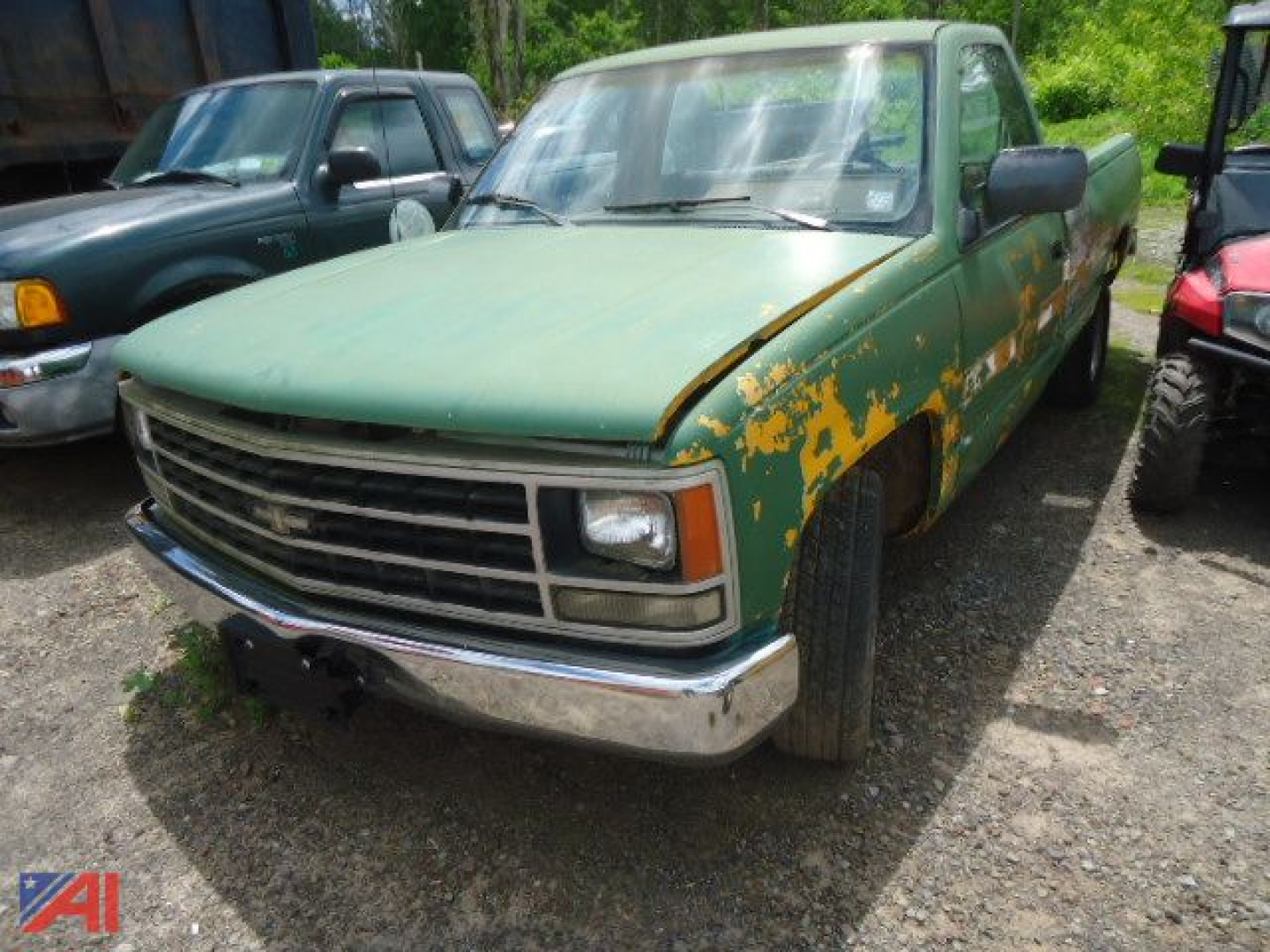 Chevrolet K-series pickup truck from 1991 in green with extensive paint flaking and front chrome bumper, 2WD long bed, parked among other vehicles.