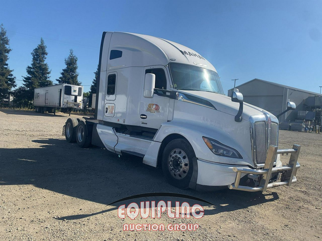 Kenworth T680 tractor unit from a front-right angle with a chrome grille, white cab, and bumper guard. Visible text includes EQUIP…N GROUP logo on ground yard.
