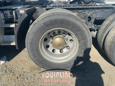 Kenworth T680 wheel and fuel chassis area showing single rear dual axle with tire; visible branding on wheel hub and mudguard; Equupling Auction Group watermark on ground