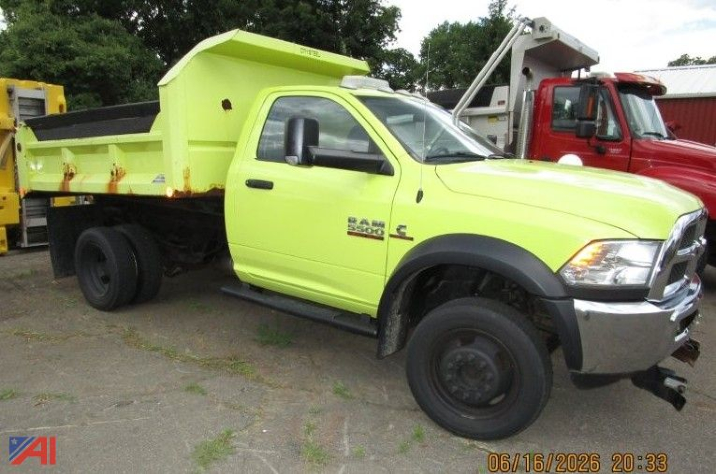Ram 5500 dump truck with plow, lime-green dump bed, side view showing front grille and heavy-duty bumper.
